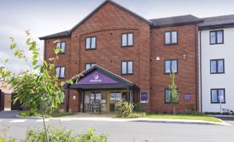 "a brick building with a purple sign that reads "" travelodge "" on the side of the building" at Oswestry