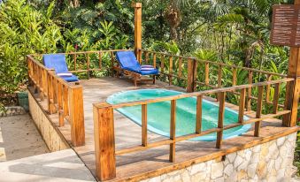 a wooden deck with a hot tub and lounge chairs , surrounded by lush greenery and trees at Camino Real Tikal‎