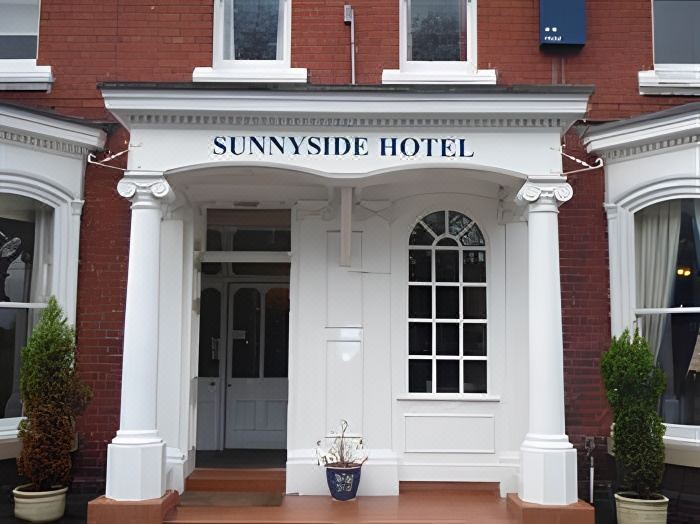 "the entrance to a building with the name "" sunnyside hotel "" on top of the door" at Sunnyside Hotel