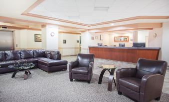 a well - lit waiting room with several chairs and couches , providing a comfortable environment for guests at Ramada by Wyndham Estevan