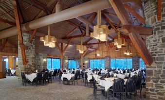 a large , well - lit banquet hall with multiple tables and chairs arranged for a formal event at Pocono Palace Resort