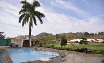 a large swimming pool with a palm tree in the middle and mountains in the background at Hotel Lake View