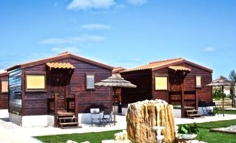 a beautiful wooden house with a large pool and a fountain in front of it at Hotel Neptuno