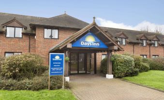 the days inn hotel with its entrance sign and brick walls , under a clear blue sky at Days Inn by Wyndham Sevenoaks Clacket Lane
