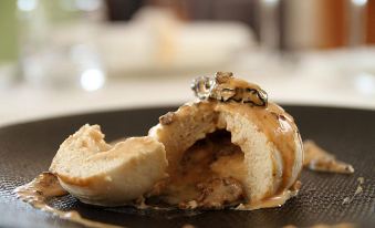 a piece of bread with a piece of bread missing is sitting on a plate at La Cascade