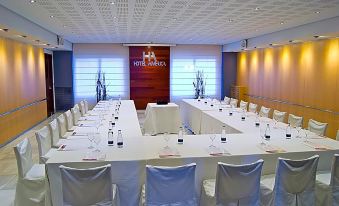 a large conference room with white tables and chairs , set up for a meeting or event at Hotel America Igualada