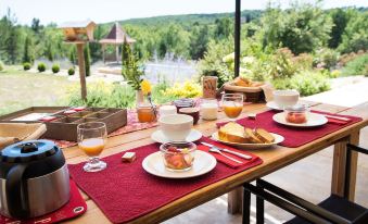 a dining table set with a variety of food items , including bread , fruits , and drinks at Le Lion d'Or en Perigord