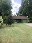 Lakeside house with fireplace, deck, and a fenced backyard with firepit.
