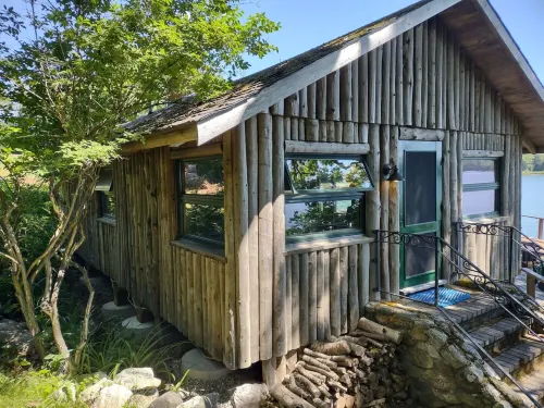 Cozy waterfront log cottage with huge outdoor living area.