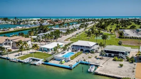 Watch dolphins play in Shelter Cove while swimming in our oversized  pool Отели в г. Key Colony Beach