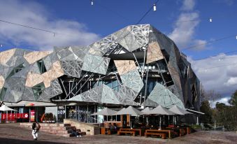 a modern building with a unique architectural design , situated next to an outdoor seating area at The Snug