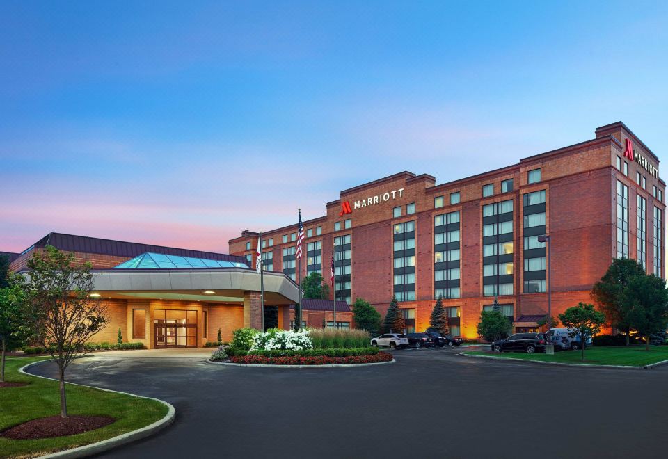 a large hotel with a red brick exterior and a large glass window , surrounded by a parking lot at Cleveland Marriott East