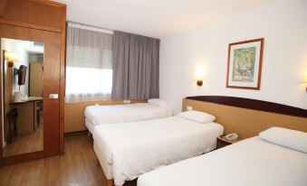 a hotel room with three beds , two of which are twin beds and one is a double bed at Campanile Barcelona