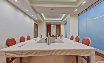 a conference room set up for a meeting , with multiple chairs arranged in a semicircle around a long table at Marin Hotel