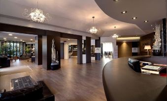 a modern hotel lobby with wooden floors , black walls , and chandeliers , as well as a reception desk at Hotel Park