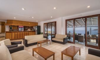 a large room with multiple couches and chairs arranged in a seating area , creating a cozy atmosphere at Lena Beach Hotel