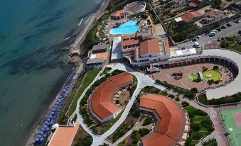 aerial view of a resort with a large pool surrounded by buildings , located near the ocean at La Plage Resort