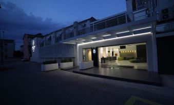 a modern building with a glass entrance and several cars parked outside , under a dark sky at Hotel Artemide