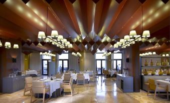 a large dining room with wooden floors and tables , chairs , and a ceiling adorned with wooden beams at Parador de Lorca