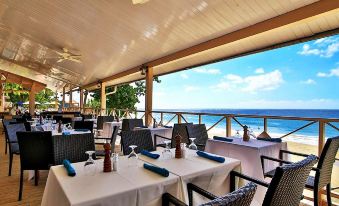an outdoor dining area with tables and chairs set up for a group of people to enjoy a meal at Grafton Beach Resort