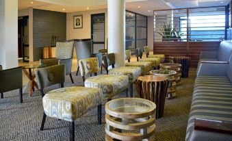 a hotel lobby with various seating options , including couches and chairs , as well as a coffee table at Indaba Lodge Gaborone