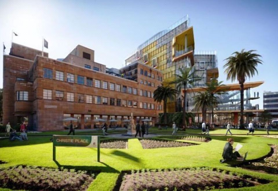 a modern building with a yellow facade and a green roof , surrounded by lush green grass and palm trees at Sleepy Hill Motor Inn