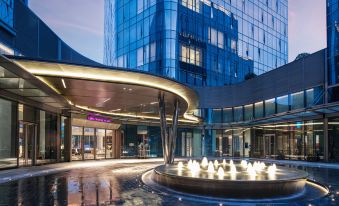 The hotel entrance features large windows and an outdoor seating area in front at Crowne Plaza Shanghai Hongqiao
