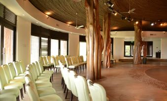 a large room with chairs arranged in rows , likely for a meeting or event , surrounded by wooden poles at Nayara Hangaroa
