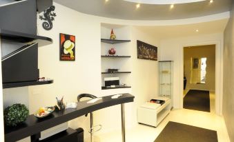 a small room with a white ceiling , black and white furniture , and various items on shelves at Magic Rainbow