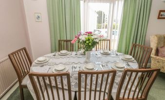 a dining room with a table set for six , complete with chairs and a vase of flowers at Canina