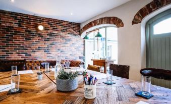 a wooden dining table with chairs and a brick wall in the background , creating an inviting atmosphere at Lisnacurran