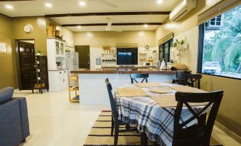 a dining room with a table and chairs , as well as a kitchen with a refrigerator and microwave at Kampung Bongsu Farmstay