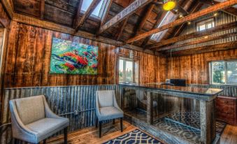 a room with wooden walls and ceiling , two chairs , and a large painting on the wall at The Cannery Lodge