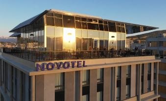 "a large building with the words "" novotel "" written on it , situated on a city street" at Novotel Annemasse Centre - Porte de Genève