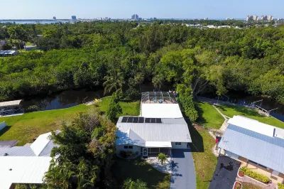 NEW! Waterfront Heated Pool, Kayaks, Fishing Pier, Fire Pit w/office Hotels near The Shell Factory and Nature Park