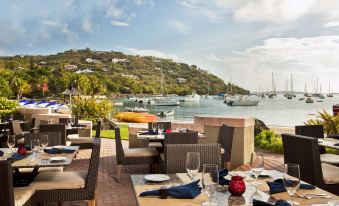 an outdoor dining area with tables and chairs set up for a meal , overlooking a body of water at The Westin St. John Resort Villas