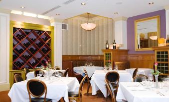 a well - decorated restaurant with multiple dining tables and chairs , creating a warm and inviting atmosphere at Carleton of Oak Park