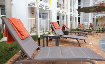 a patio with several lounge chairs and umbrellas , creating a relaxing outdoor seating area for guests at Hotel Saint - Georges