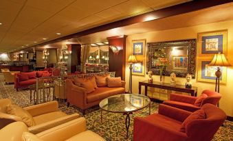 a large , well - lit room with multiple couches and chairs arranged in various positions for guests to relax at Holiday Inn Johnstown-Downtown