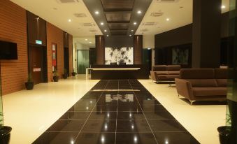 a modern hotel lobby with black tiles on the floor , white walls , and a large reception desk at Star Well Hotel