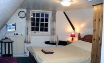 a room with two beds , one on the left and one on the right side of the room at Three Horseshoes Inn