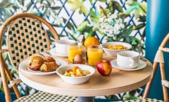 a breakfast table with a variety of food items , including fruit , pastries , and a cup of coffee at Best Western the Public Hotel