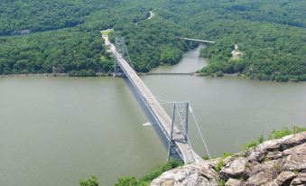 a large bridge spanning across a body of water , with mountains in the background and a rocky cliff on one side at Hilton Garden Inn Nanuet