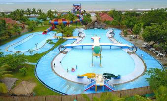 an aerial view of a large water park with multiple water slides and a beach in the background at Coconut Island Carita