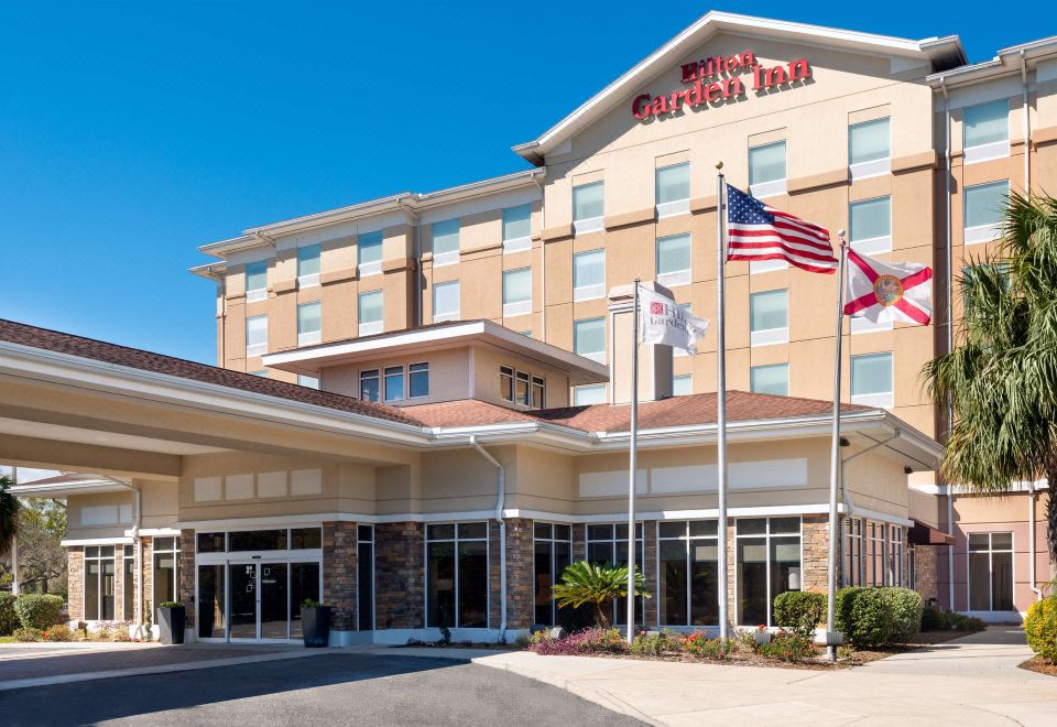 a hotel with a large american flag flying in front of it , surrounded by other flags and buildings at Hilton Garden Inn Tampa/Riverview/Brandon