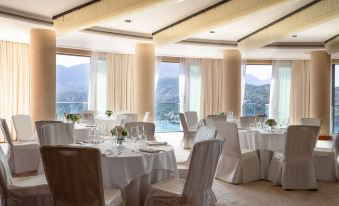 a large dining room with white tables and chairs , set up for a formal event at Jumeirah Port Soller Hotel and Spa