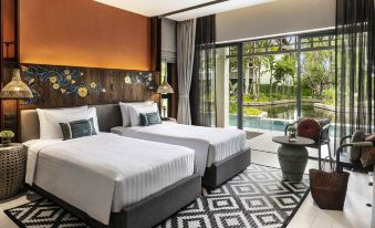 a modern hotel room with two beds , a chair , and a window offering a view of a garden at Grand Mercure Khao Lak Bangsak