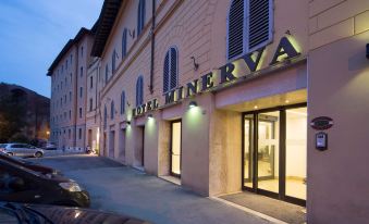 "a large building with the name "" hotel minerva "" displayed above the entrance , illuminated at night" at Hotel Minerva