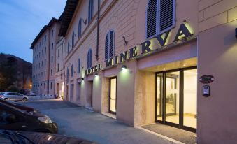 "the entrance of a building named "" hotel minerva "" with the name lit up above it" at Hotel Minerva