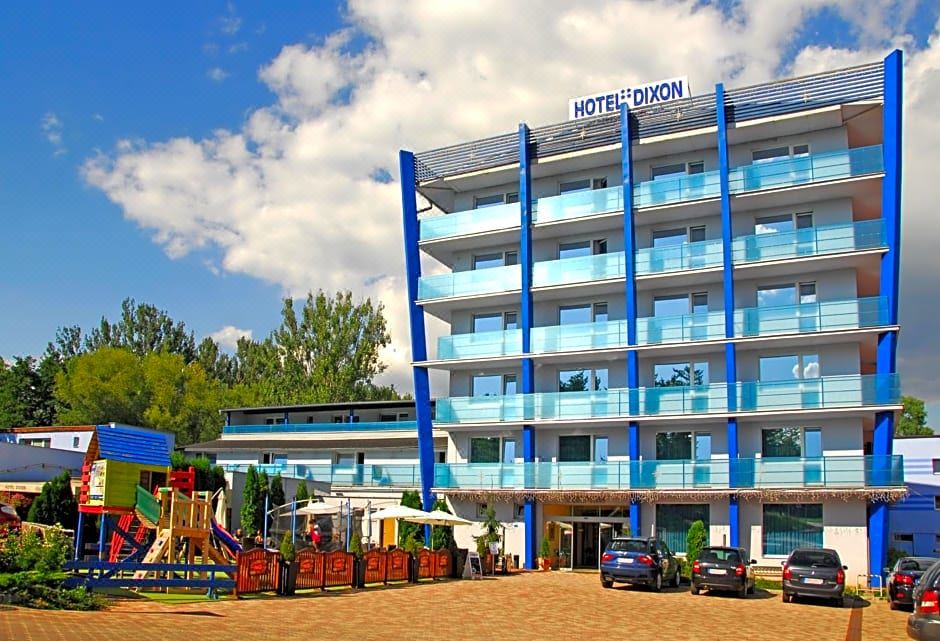 "a blue hotel building with a sign that says "" hotel dizon "" on it , surrounded by other buildings and trees" at Hotel Dixon so Vstupom do bazéna a vírivky Zdarma - Free Entrance to Pool and Jacuzzi Included